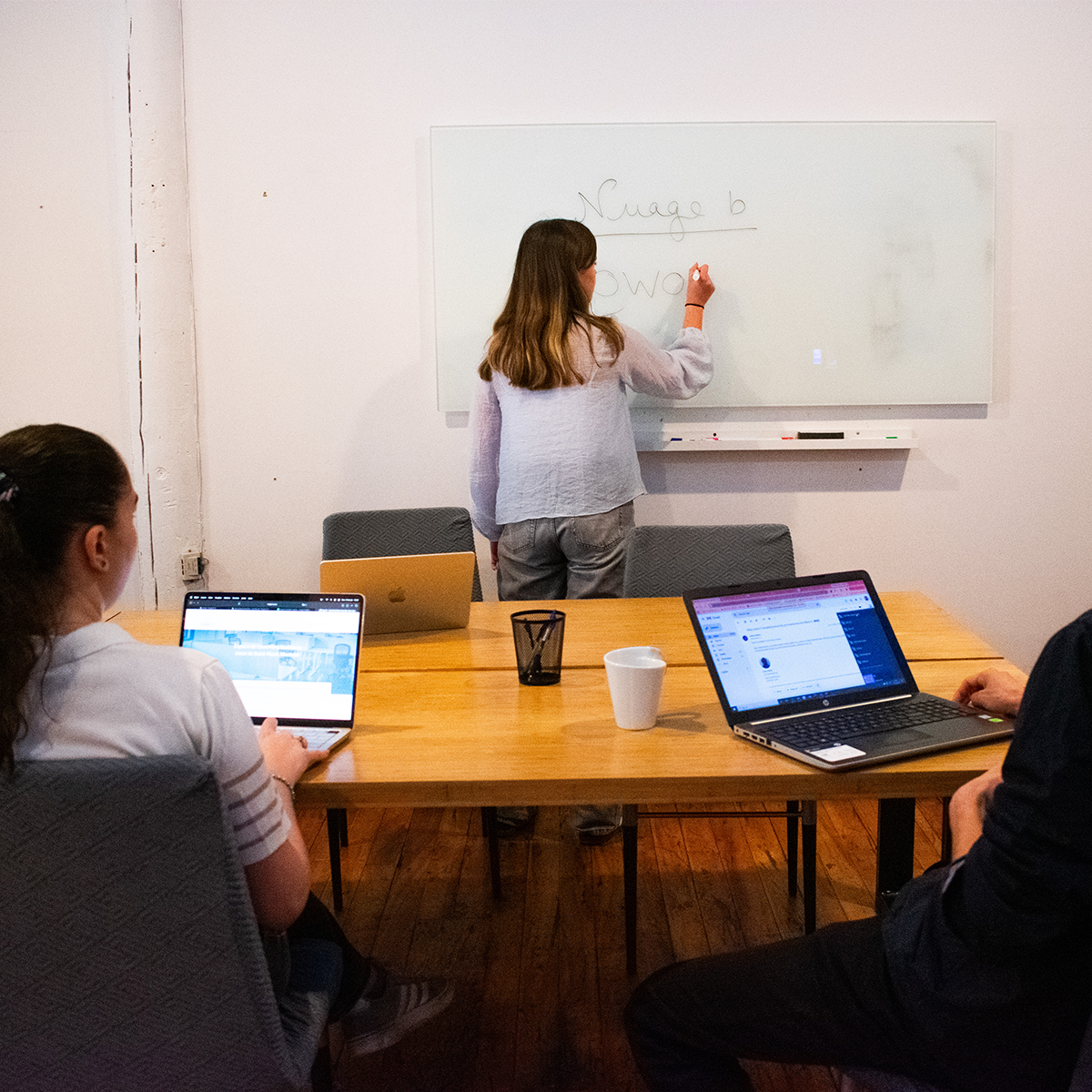 Team workshop at Nuage-B event space in Saint-Henri, Montreal — active presentation with professionals collaborating around a table
